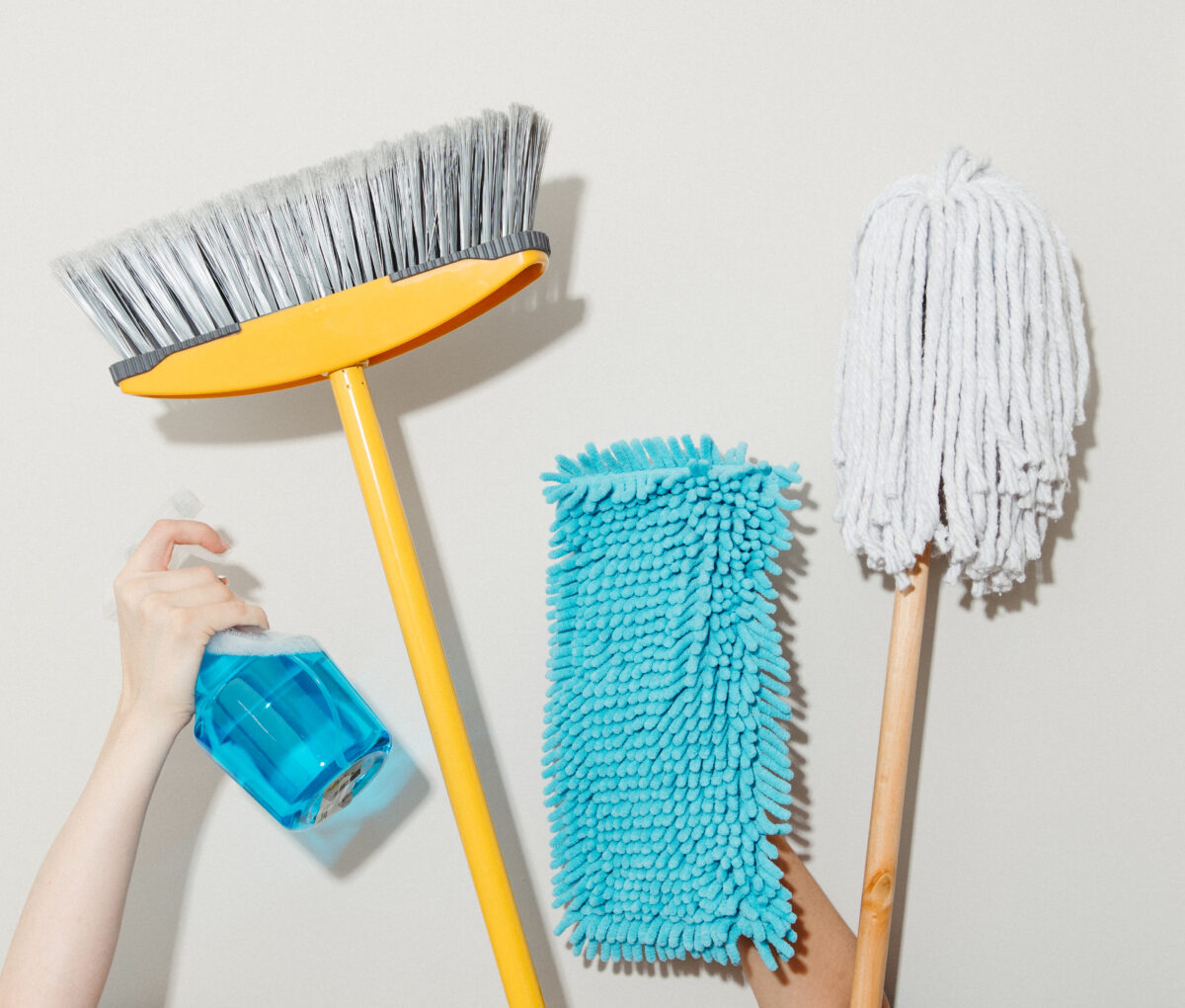 Broom, mop, microfibre duster and spray bottle ready for a post renovation clean